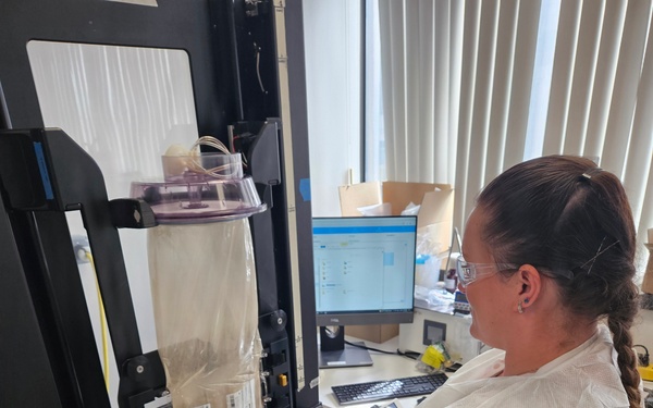 U.S. Navy Hospital Corpsman First Class Kristen Gordon Operates a Specialized Sealer for Spray-Dried Plasma Production