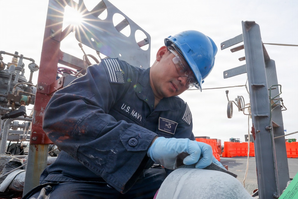 Bataan Sailors Sand a Fuel Station for Repainting
