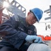 Bataan Sailors Sand a Fuel Station for Repainting