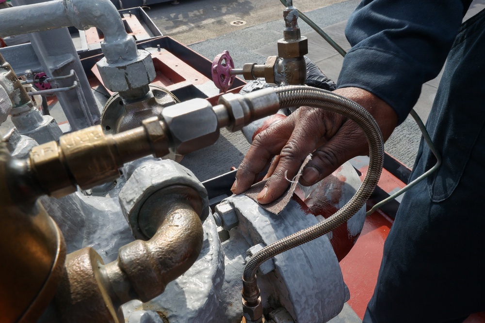 Bataan Sailors Sand a Fuel Station for Repainting