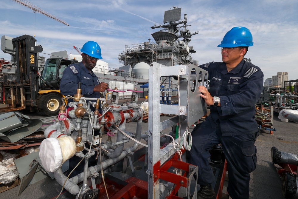 Bataan Sailors Sand a Fuel Station for Repainting