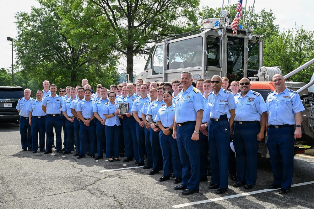 U.S. Coast Guard personnel pose for group photo with response boat during awards ceremony