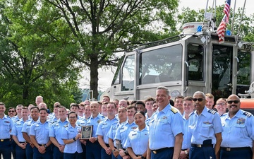 U.S. Coast Guard personnel pose for group photo with response boat during awards ceremony