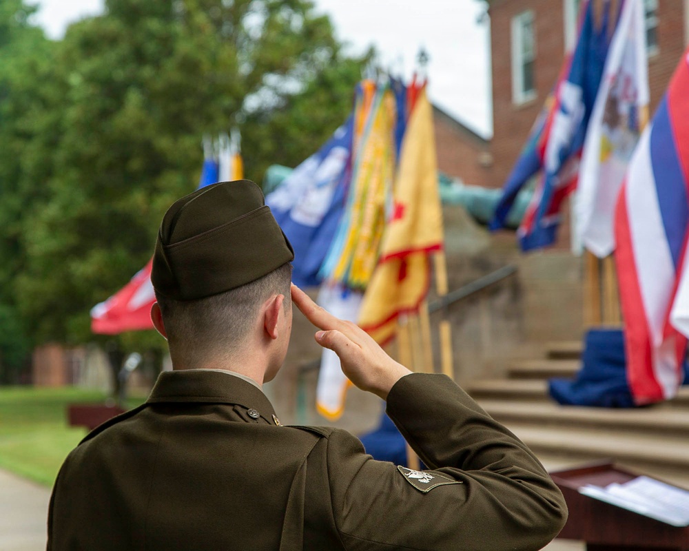 U.S. Army officer renders salute during military ceremony with unit colors on display