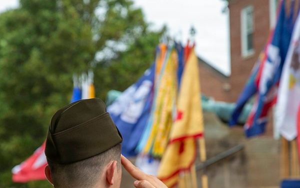 U.S. Army officer renders salute during military ceremony with unit colors on display