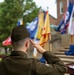 U.S. Army officer renders salute during military ceremony with unit colors on display