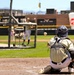 Baseball catcher in full gear receives pitch during batting practice at collegiate stadium
