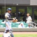 Baseball catcher in full gear stands near dugout during game at modern stadium