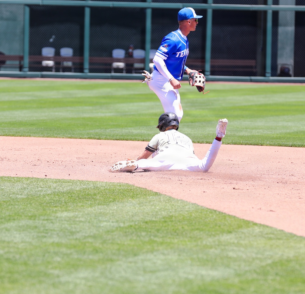 Base runner slides into second as Temple University infielder leaps to complete play during college baseball game