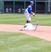 Base runner slides into second as Temple University infielder leaps to complete play during college baseball game