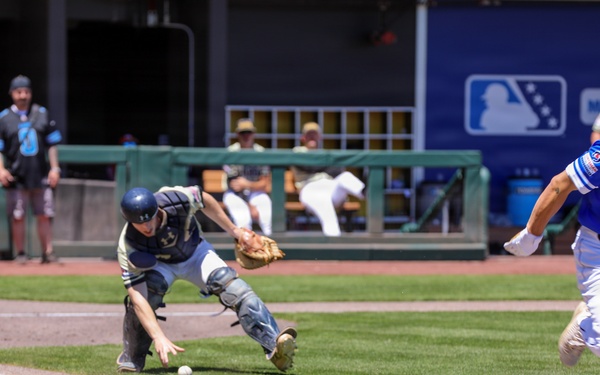 Team HHI batter races to first base as catcher lunges for dropped ball during MLB-affiliated military baseball game