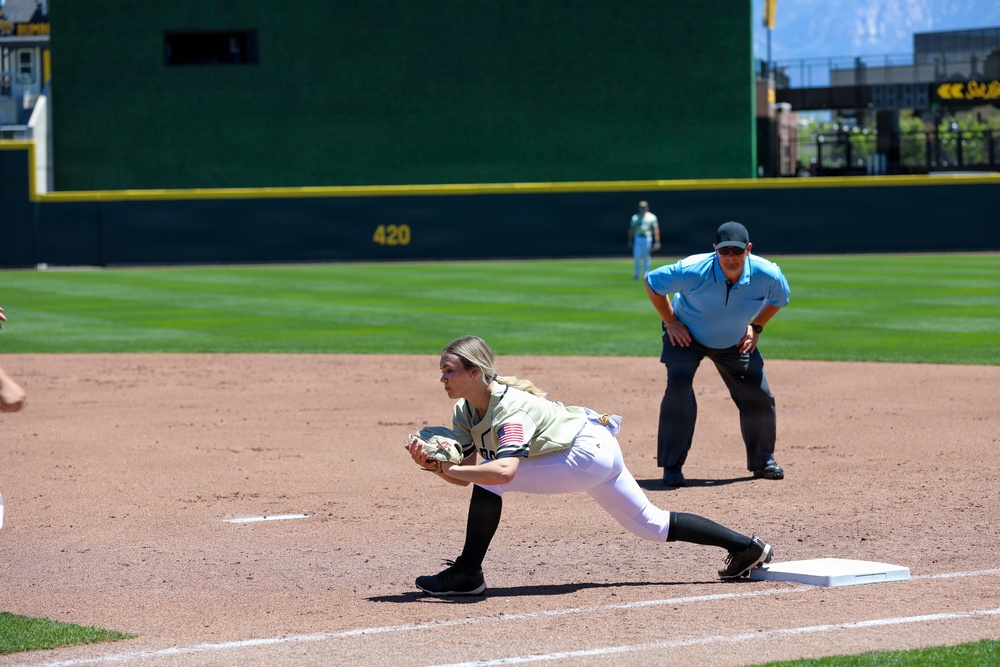 Softball player fields ball at first base during military appreciation game
