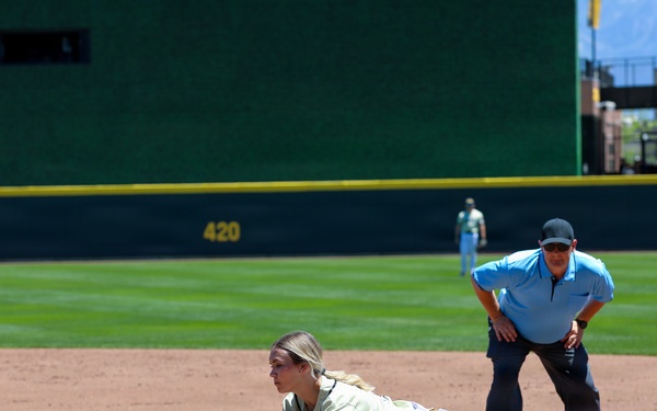 Softball player fields ball at first base during military appreciation game