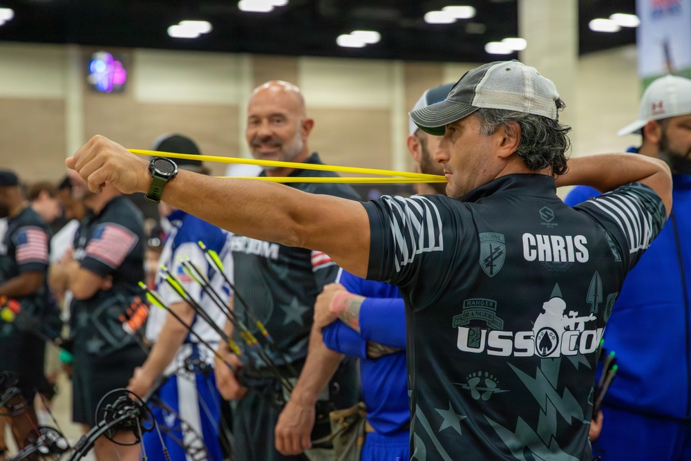 SOCOM competitor stretches before archery event