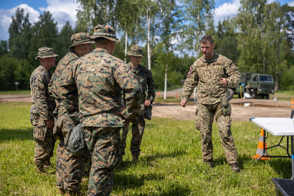 U.S. Marines and Latvian soldiers conduct a decontamination zone in the Baltic region
