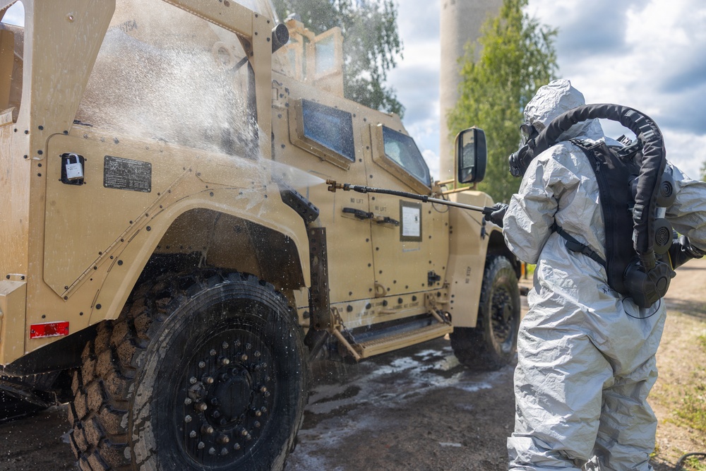 U.S. Marines and Latvian soldiers conduct a decontamination zone in the Baltic region