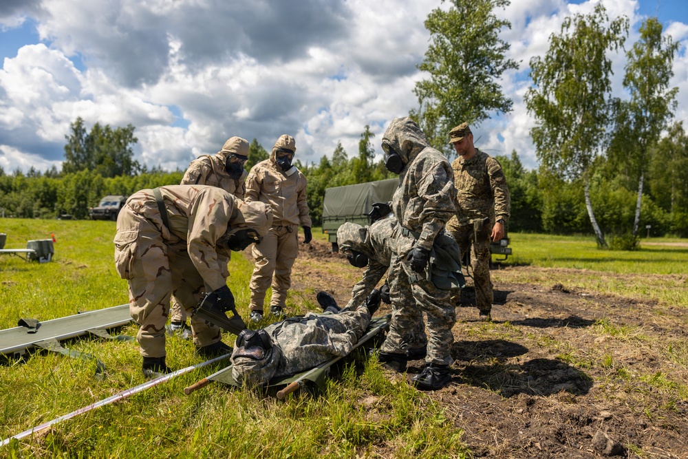 U.S. Marines and Latvian soldiers conduct a decontamination zone in the Baltic region