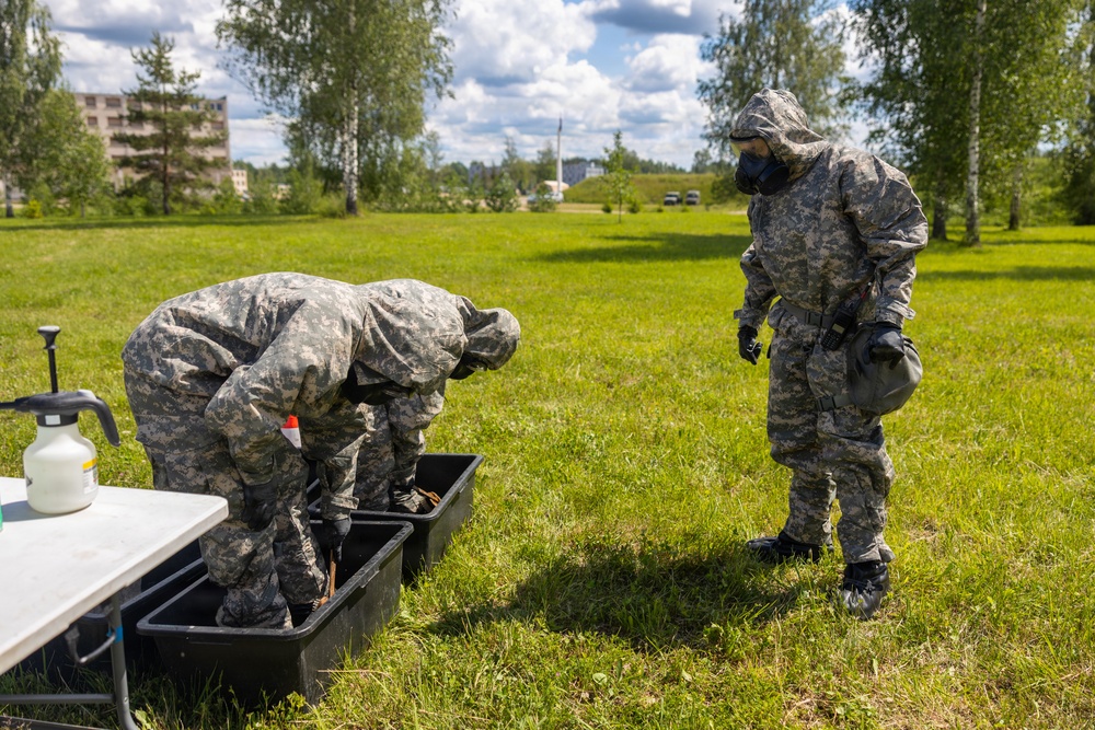 U.S. Marines and Latvian soldiers conduct a decontamination zone in the Baltic region