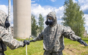 U.S. Marines and Latvian soldiers conduct a decontamination zone in the Baltic region