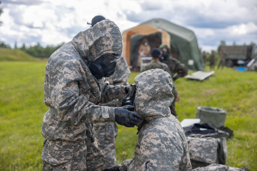 U.S. Marines and Latvian soldiers conduct a decontamination zone in the Baltic region