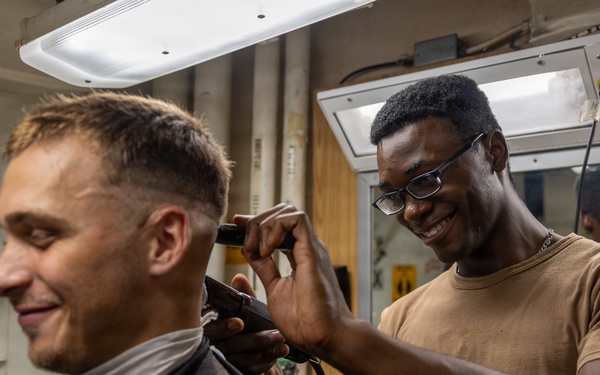 USS Ross Sailor cuts hair in the barbershop