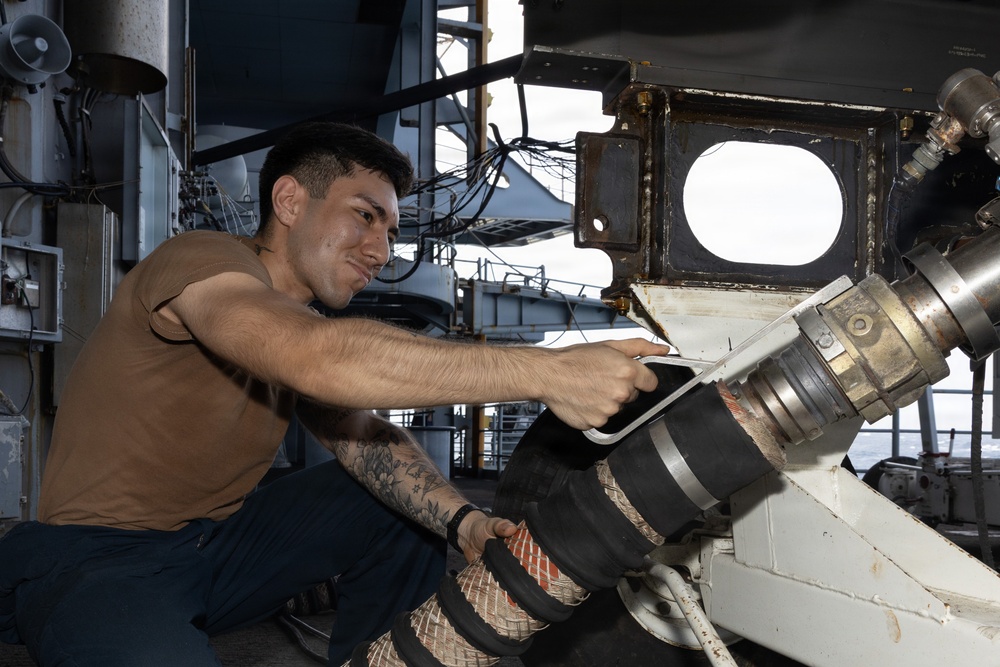 USS George H.W. Bush Sailor attaches a fueling hose