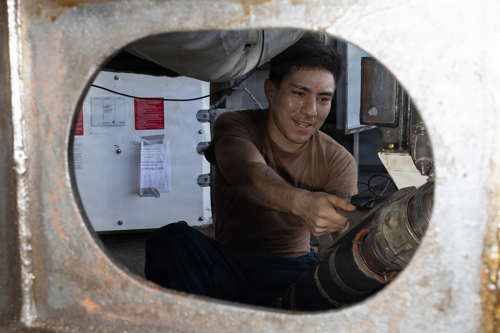 USS George H.W. Bush Sailor attaches a fueling hose