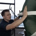 USS George H.W. Bush Sailor places a protective mesh over the intake