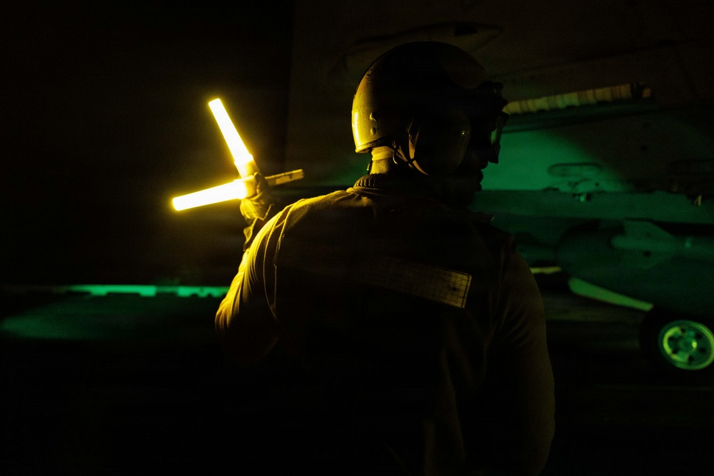 USS George H.W. Bush signals an F/A-18E Super Hornet