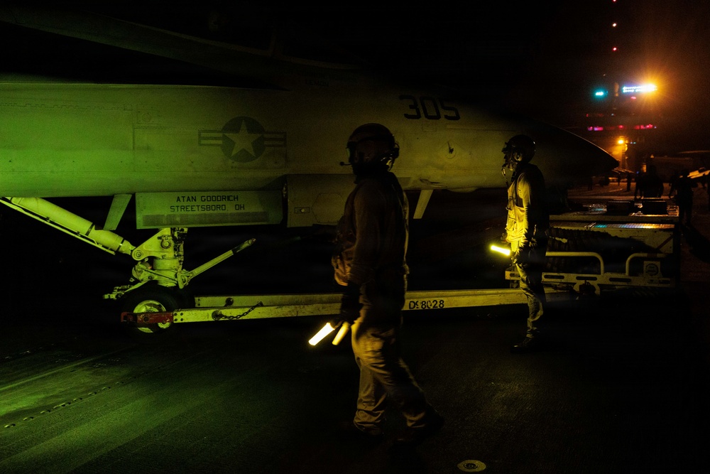 USS George H.W. Bush signals an F/A-18E Super Hornet