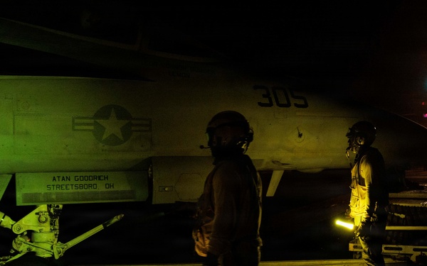 USS George H.W. Bush signals an F/A-18E Super Hornet