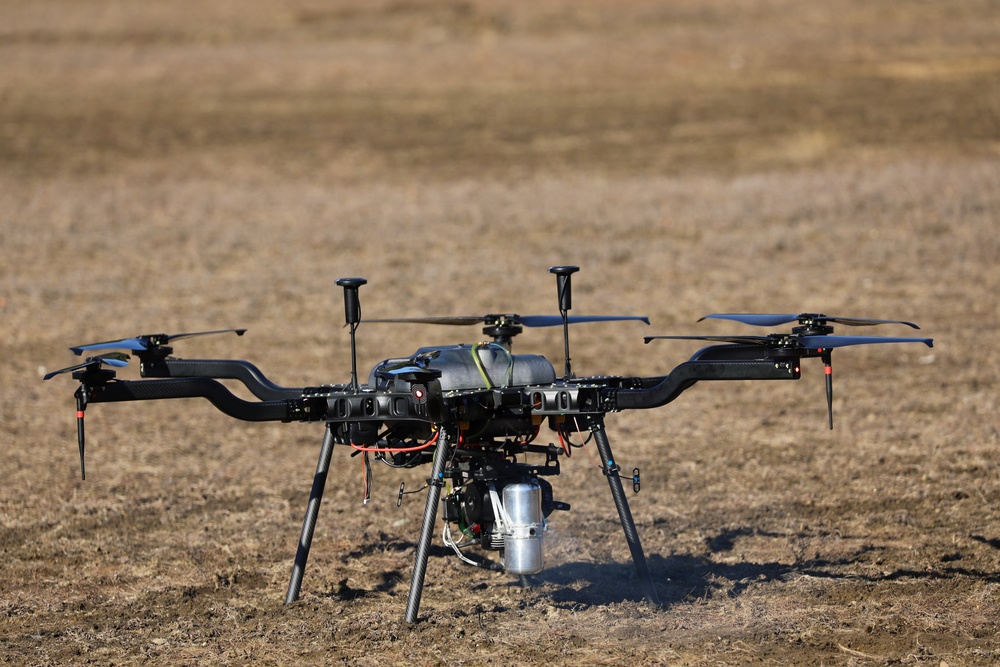 A UAS drone prepares for liftoff in a field during a technical training exercise.