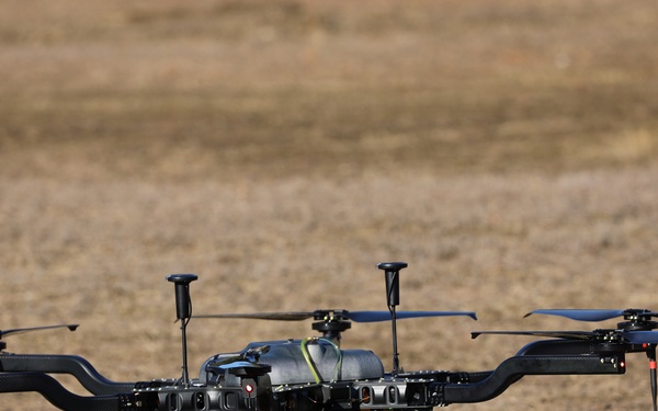 A UAS drone prepares for liftoff in a field during a technical training exercise.