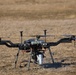 A UAS drone prepares for liftoff in a field during a technical training exercise.