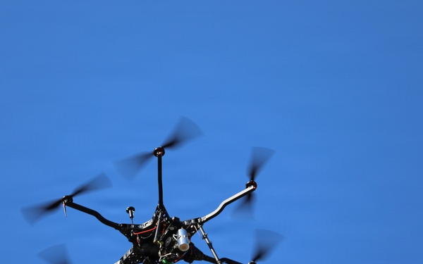 Multi-Rotor UAS Drone in Flight Against Clear Blue Sky
