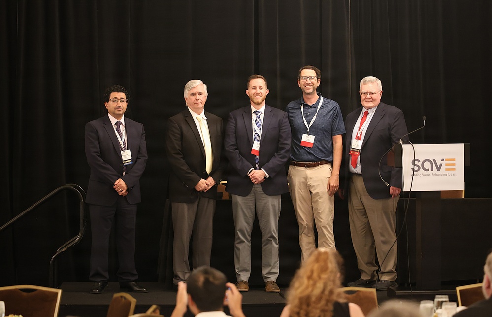 USACE employees pose on stage at SAVE International conference after receiving awards.