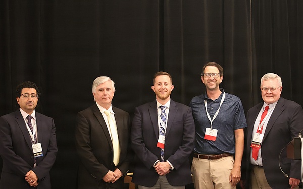 USACE employees pose on stage at SAVE International conference after receiving awards.