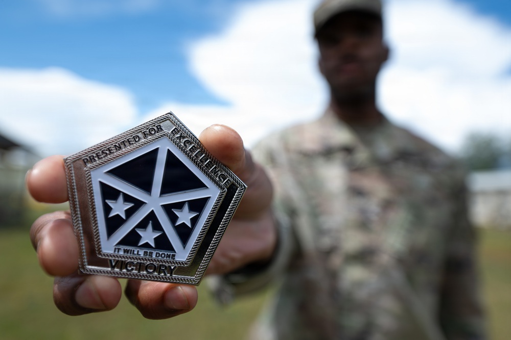Staff Sgt. Makonnen Francis poses with V Corp Coin (Front)