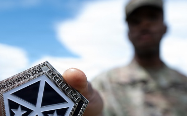 Staff Sgt. Makonnen Francis poses with V Corp Coin (Front)