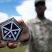 Staff Sgt. Makonnen Francis poses with V Corp Coin (Front)