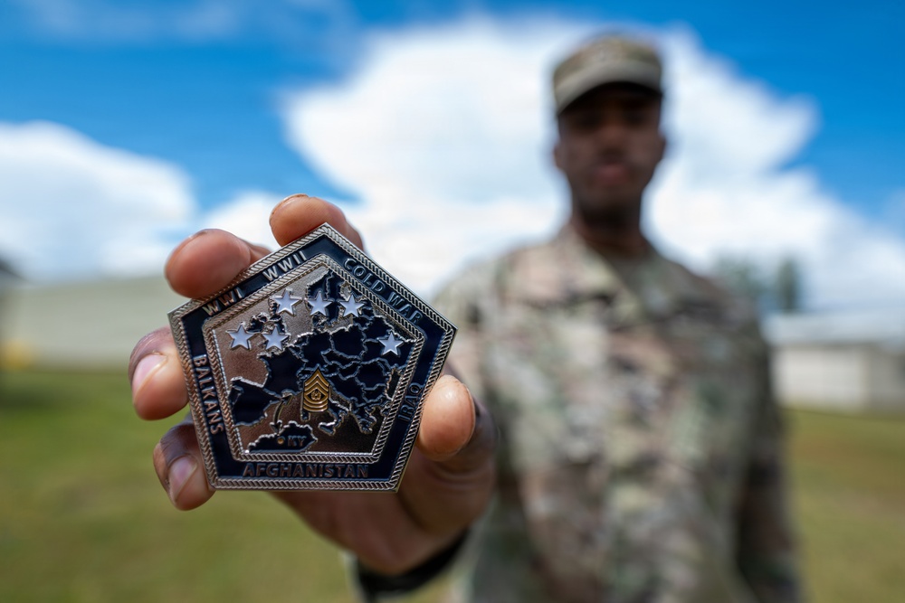 Staff Sgt. Makonnen Francis poses with a V Corps' Coin (Rear)