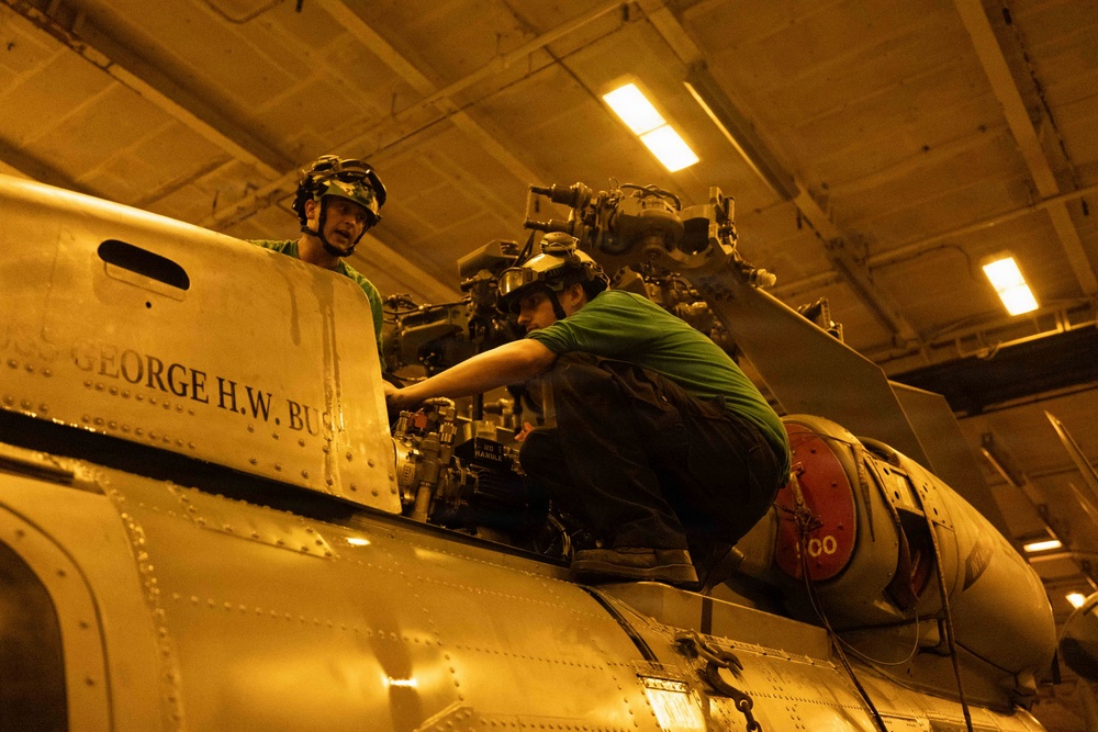 USS George H.W. Bush maintain an MH-60R Sea Hawk
