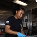 USS George H.W. Bush Sailor cuts sausages