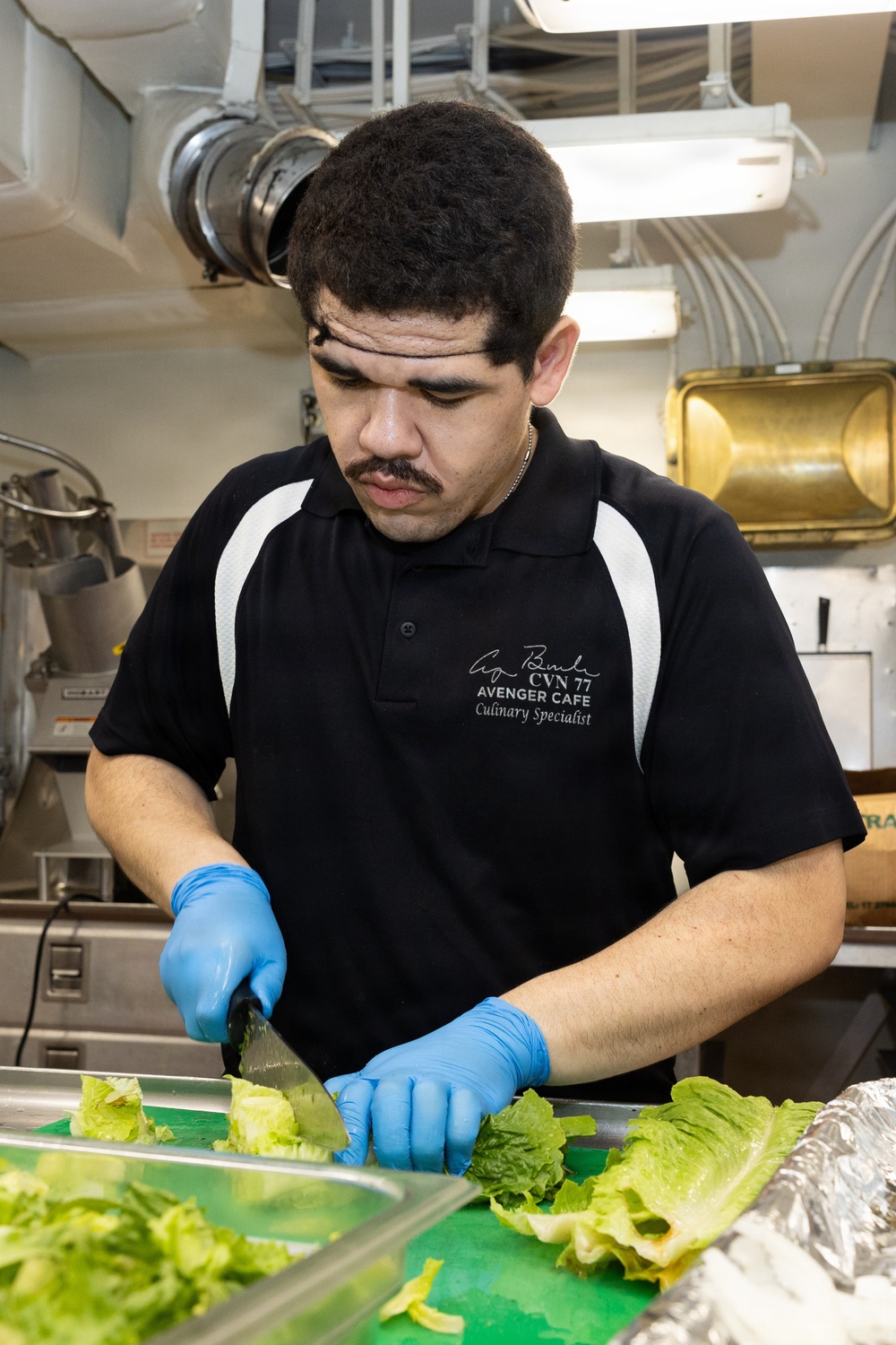 USS George H.W. Bush Sailor chops lettuce