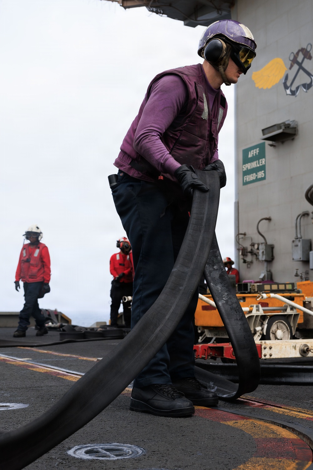 USS George H.W. Bush Sailor transports a fuel hose