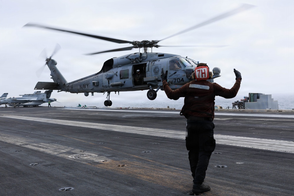 USS George H.W. Bush signals the launch of an MH-60R Sea Hawk