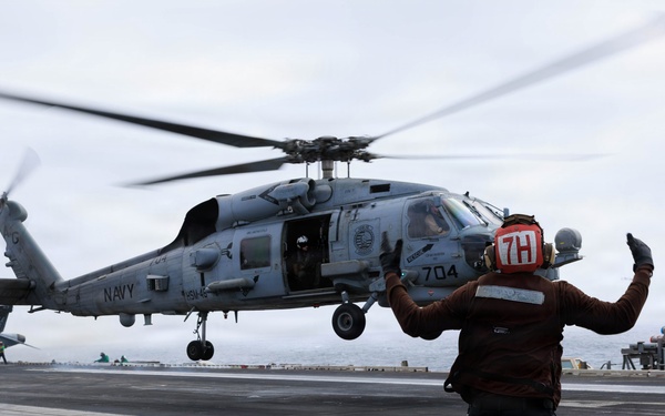 USS George H.W. Bush signals the launch of an MH-60R Sea Hawk