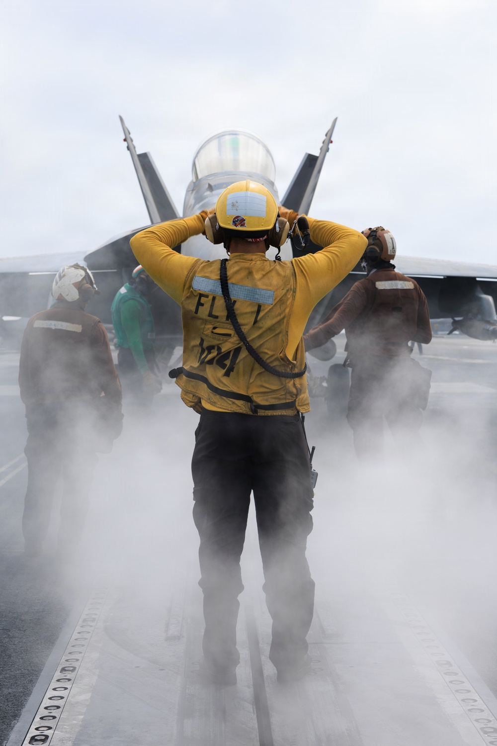 USS George H.W. Bush signals a F/A-18E Super Hornet
