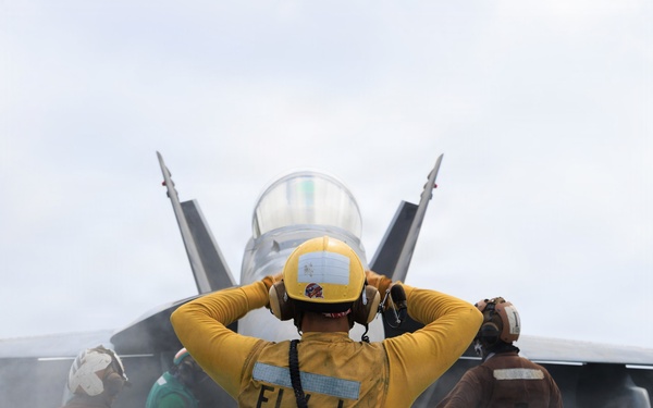 USS George H.W. Bush signals a F/A-18E Super Hornet