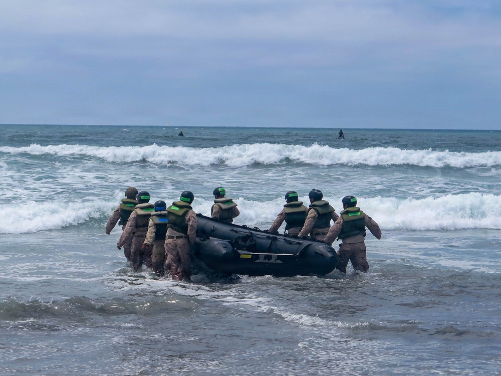 2nd Bn., 5th Marines, paddle through surf during infantry company small boat raid course